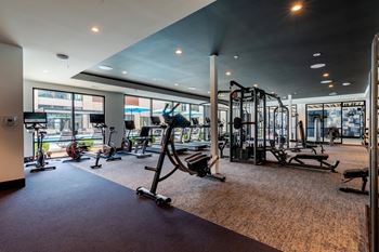 a gym with exercise equipment and large windows  at Century West Pryor, Missouri
